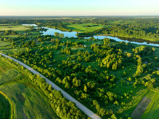 Village at lake, aerial view. Country houses at river in countryside. Roofs of country wooden...