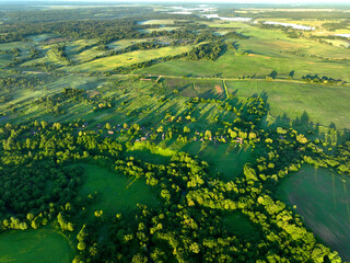 Rural landscape in Morning, drone view. Roofs of country wooden houses near a pond in village....