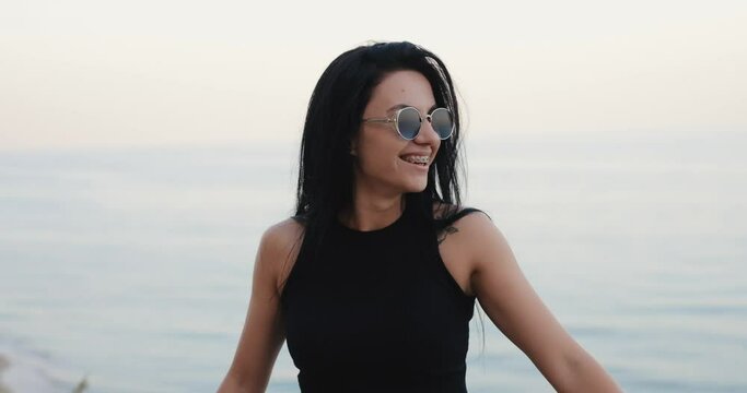 Smiling woman in the braces on her teeth at the sea view