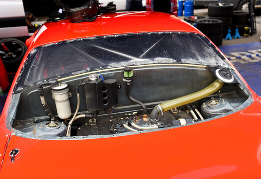 Racing car gas tank. Sports car engine with turbine. An open race car hood on a pit stop while racing on a race track. Motor with turbocharger. Boos and tunning.