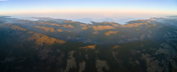 Beautiful mountain panoramic landscape with hazy peaks and foggy valley at sunset