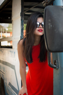 Woman dressed in red dress, casual and sexy. With dark glasses. black hair Holidays. Mountain hotel with swimming pool. Girl riding a bus. Reading magazine. Girl with suitcase