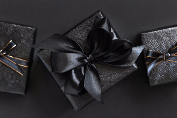 Black Gift Boxes with a ribbon bow on black top view
