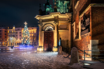 The main square in Krakow with a view of the cloth hall and St. Mary's Basilica in winter. Rynek...