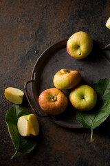 flattened apples on a metal tray on a dark background