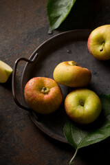 apples on a metal tray on a dark background