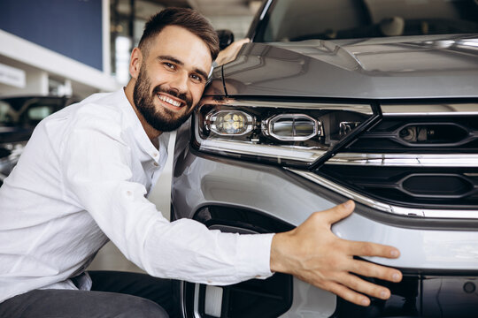 Man Hugging A New Car In A Car Showroom