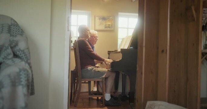 WS Senior gay couple playing piano at home / East Sussex, UK