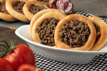 Arabian snack meat sfiha on bowl.