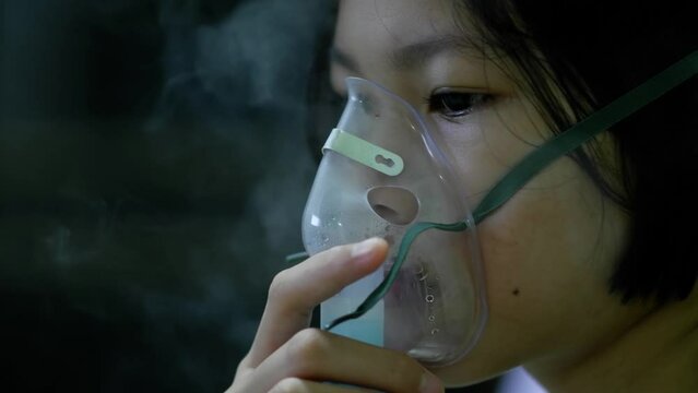 Close up sick Yong asian girl with face oxygen mask,have oxygen fumes ,on bed in hospital, Healthcare workers in the Coronavirus Covid19 pandemic