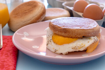 un muffin oeuf et fromage dans une assiette	