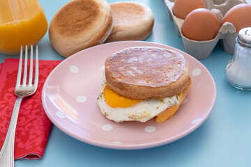 un muffin oeuf et fromage dans une assiette	