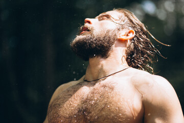 Handsome man with wet hair  in forest