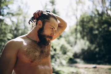 Handsome man with wet hair  in forest