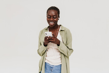 Young stylish smiling african woman in headphones with phone