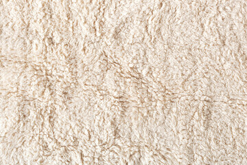 Beige soft ecological fur textile background, closeup