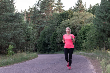 Fototapeta premium a young girl runs in the woods Doing sports Healthy lifestyle