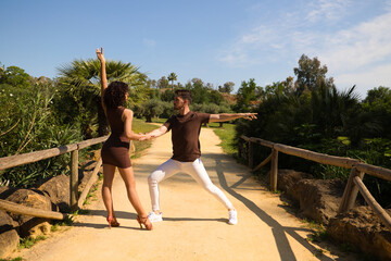 Handsome young man and woman dancing bachata and salsa in the park. The couple dance passionately...
