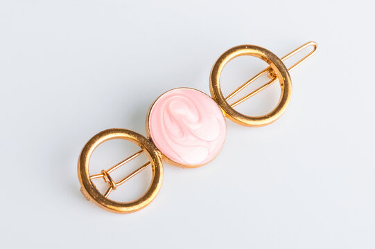 Modern hair clip, gold color with pink insert. Close-up