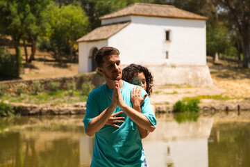 beautiful woman and handsome man latinos dancing bachata are dancing by the river in the forest....
