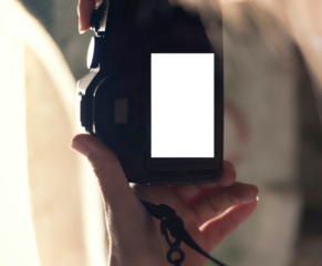 A woman taking a picture with a digital camera, in vertical orientation, with a blank rectangle instead of the viewfinder screen. Replace the white with your own creativity.

