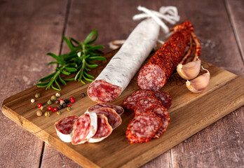 Food photography of sliced salami, sausage, garlic, pepper, rosemary