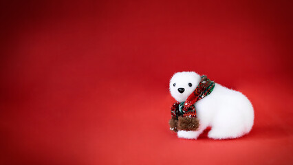 Cute polar bear in scarf on red background with copy space