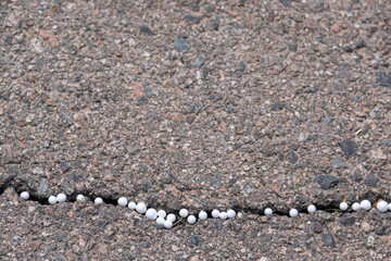 Styrofoam balls in a crack in the asphalt