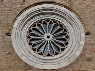 Fototapeta na wymiar Rose window on facade of medieval Crema Dome, in Cremona province, Lombardy, Italy