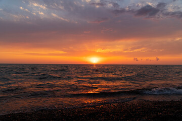 Fototapeta na wymiar Sea landscape. Beautiful sunset over the sea with bright orange clouds.