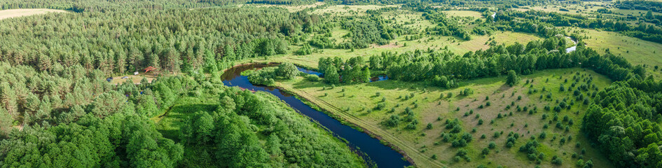 Fototapeta na wymiar Aerial landscape of winding river in green field and trees. Beautiful nature background from drone.