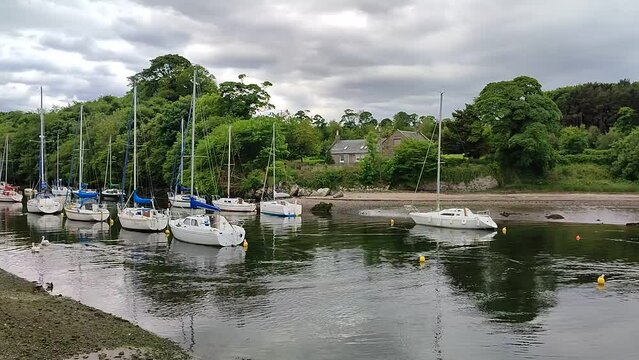 Lovely view of the boats in the Cramond village in Edinburgh, Scotland with trees in the background