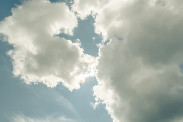 Fluffy clouds in blue sky as backdrop. Rainy weather with changes in atmospheric pressure