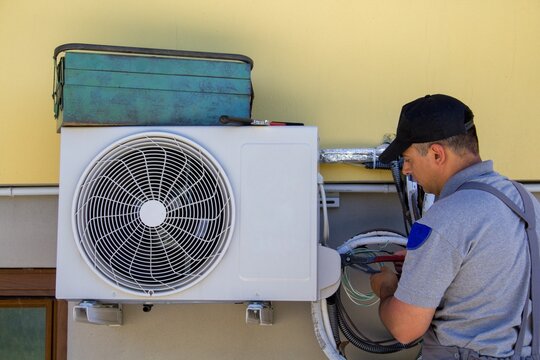 Closeup Shot Of A Mechanic Fixing An Air Conditioning Fan