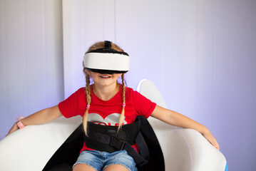 A child with a virtual reality headset, playing a game on an amusement ride or watching a 3D movie