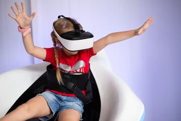 Fototapeta na wymiar A child with a virtual reality headset, playing a game on an amusement ride or watching a 3D movie