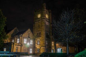 Clock tower of the University of Melbourne with lights on during the night, Melbourne, Australia