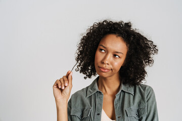 Black young woman wearing shirt frowning while looking aside