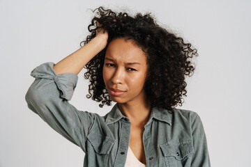 Black young woman holding her head while looking at camera