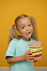 Funny girl with donuts on a yellow background