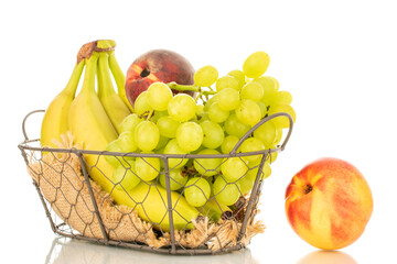 One bunch of white grapes, a bunch of bananas, an apple, a peach and a nectarine in a basket, macro, isolated on a white background.