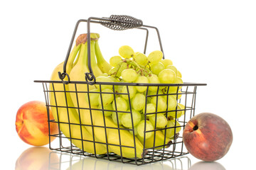 One bunch of white grapes, a bunch of bananas, an apple, a peach and a nectarine in a basket, macro, isolated on a white background.