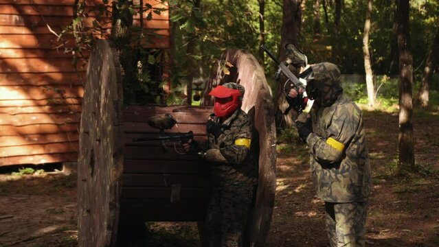 Paintball battle with friends wearing camouflage to protect themselves from the elements, a leisure activity, Paintball is an action and adrenaline sport, Outdoor game