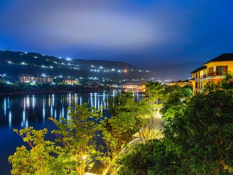 Beautiful scenery of bright green trees in the streets next to a lake in Lavasa at night
