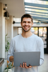 White bristle man smiling and working with laptop at office