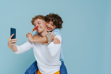 Young handsome man with beautiful woman taking selfie on phone