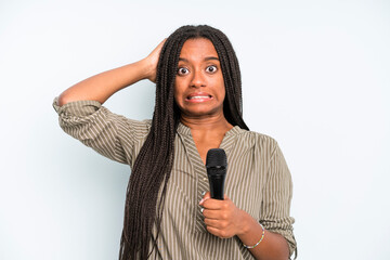 black pretty woman feeling stressed, anxious or scared, with hands on head. singer with a microphone