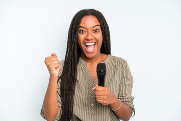 black pretty woman feeling shocked,laughing and celebrating success. singer with a microphone