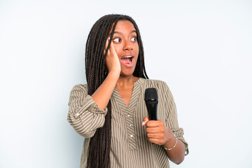 black pretty woman feeling happy, excited and surprised. singer with a microphone