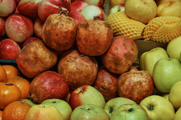 Various fruits on the counter of the farmers market close up. Apples, pomegranates, peaches and...